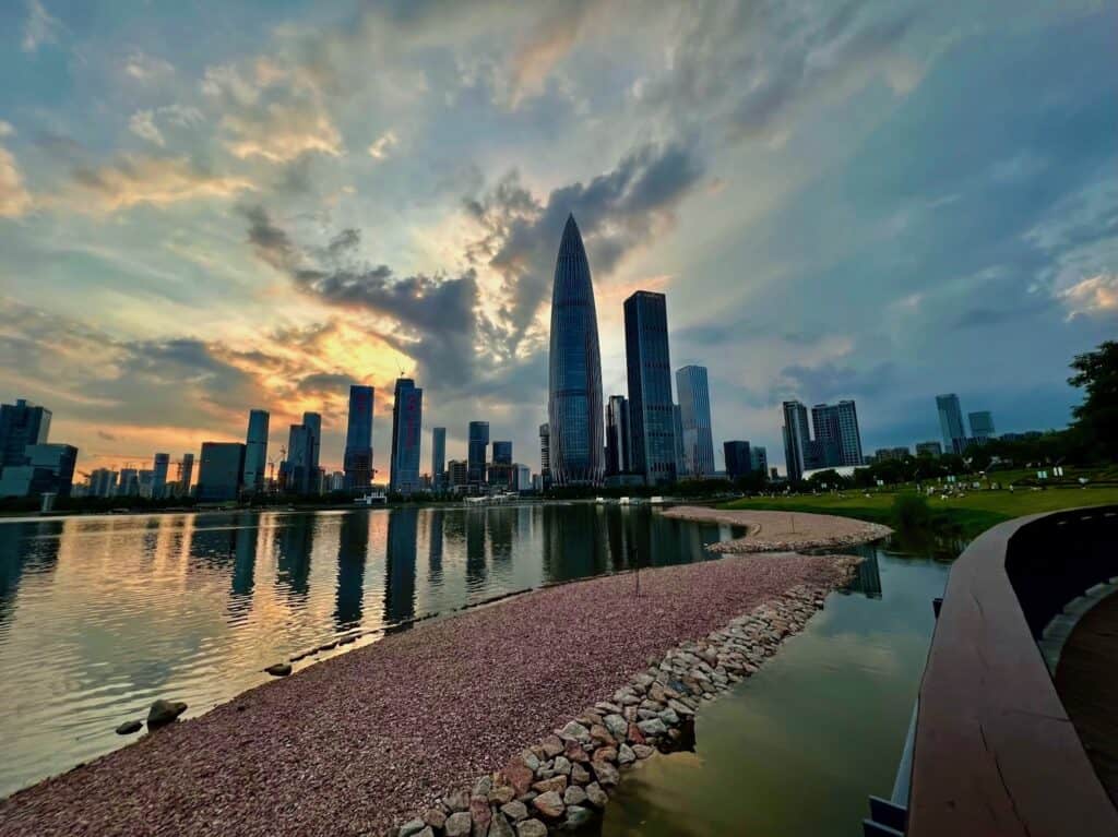 Tall glass "Bamboo" building in Shenzhen China with a sunset in the background.